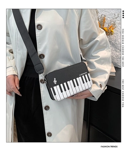 Detail view of piano key pattern on black crossbody bag with adjustable wide strap