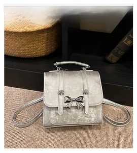 Detail of silver glitter handbag with metal butterfly clasp and sleek metallic handle