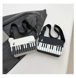 Detail view of stylish piano pattern crossbody bags in black and white music themes
