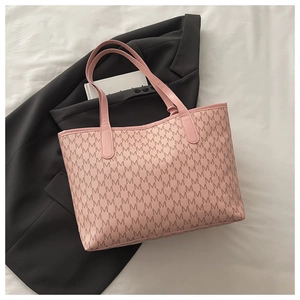 Dettaglio della borsa tote in pelle PU rosa con stampe di lettere M e manici testurizzati