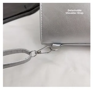Detail of silver textured leather bag with detachable shoulder strap and metal hook