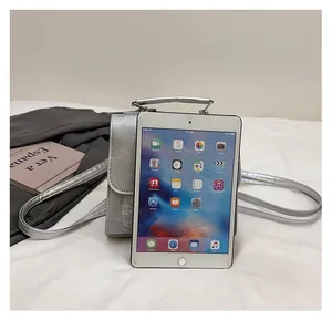 Silver metallic bag size comparison with tablet showing practical daily capacity