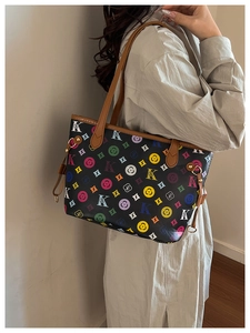 Side view of large trapezoid tote bag with colorful monogram print on a fashion model