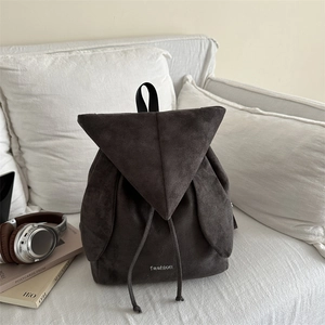 Minimalist grey suede backpack with triangular flap and drawstring for travel