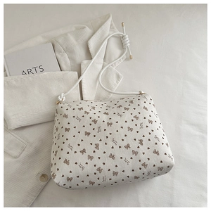 Detailed view of white ribbon tote bag with heart patterns and soft fabric texture