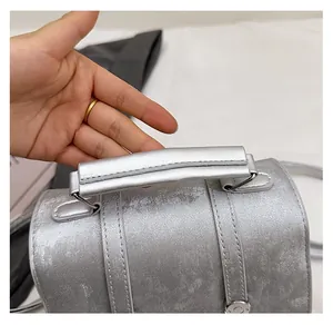 Detailed view of the silver metallic bucket bag with a thickened structured top handle