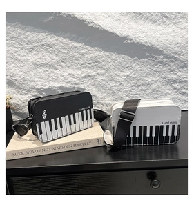 Close-up of piano keyboard pattern and I LOVE MUSIC text on leather crossbody bag