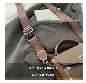 Detail of coffee woven strap with silver metal adjustment buckle and brand lettering