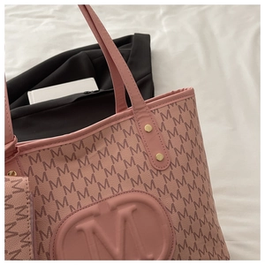 Close-up of pink tote bag with all-over M monogram print and circular embossed logo