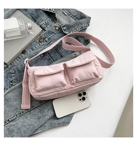 Detailed close-up of a pink quilted nylon crossbody bag featuring double front pockets