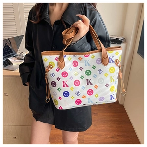 Detail of floral printed tote bag with brown leather handles and golden metal hardware