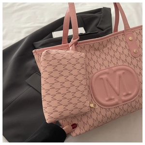 Pink faux leather tote bag with M-pattern print and matching pouch on black blazer