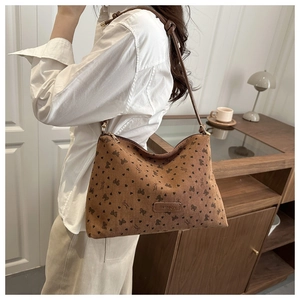 Detail of corduroy shoulder bag featuring heart patterns and fashion leather patch