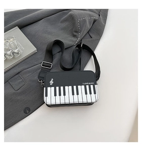 Detail of piano keyboard crossbody bag featuring music notes and I Love Music slogan