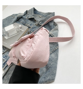 Detail view of the pink quilted nylon crossbody bag with spacious side gusset and soft texture