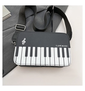 Detail of piano themed crossbody bag featuring black and white keys and musical notes