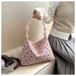 Detail of pink corduroy tote bag featuring black bow patterns and knotted rope handle