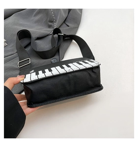 Detail of creative piano keyboard crossbody bag featuring I LOVE MUSIC slogan print