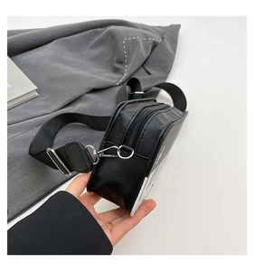 Detail view of the black piano crossbody bag showing side capacity and striped leather texture