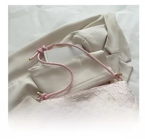Detail of light pink canvas bag featuring embossed texture and colorful embroidery