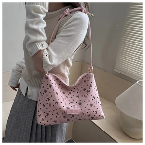 Detail of pink bow shoulder bag showing textured fabric and knotted leather strap