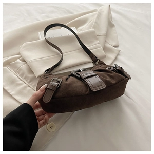 Détail d'un sac à bandoulière en daim marron avec plusieurs boucles en métal