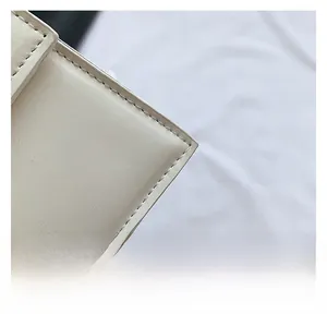 Détail macro du cuir crème de haute qualité et des coutures précises sur le sac à main