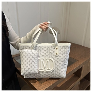 Detail of white tote bag set with M-letter monogram pattern and small zipper pouch