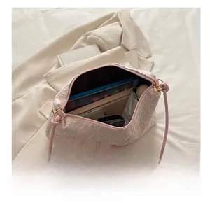 Pink quilted shoulder bag interior showing capacity for tablet, wallet, and umbrella
