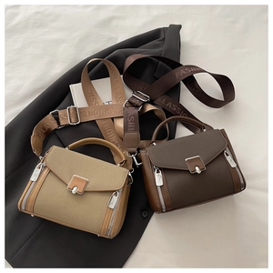 Close-up of retro canvas and leather handbags with wide jacquard straps and metal buckles
