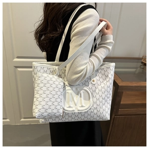 Seitenansicht der weißen Totebag mit M-Print und kleiner Tasche am Model getragen