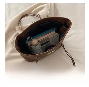 Detailansicht der großen Kapazität und Innenfächer der braunen Shopper-Tasche