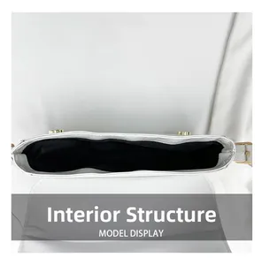 Top view of white croc-embossed bag interior with black lining and gold hardware