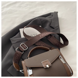 Close-up of brown litchi pattern PU handbag with a wide fashion and classic strap