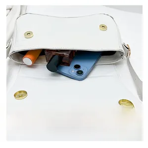 Interior storage view of white crocodile pattern shoulder bag with phone and cosmetics