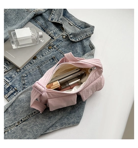Pink quilted nylon crossbody bag showing spacious interior with pockets and daily items