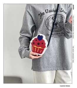 Detail view of a cute cupcake-shaped crossbody bag with heart detail and stitching