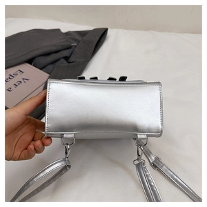 Detailed bottom view of silver bow backpack featuring metallic ring and leather texture