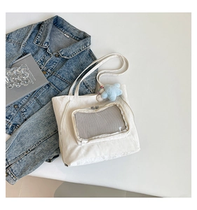 Détail de la poche transparente sur tote bag en nylon blanc et breloque étoile