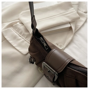 Détail du sac seau en daim marron foncé avec boucle en cuir et ferrures métalliques vintage