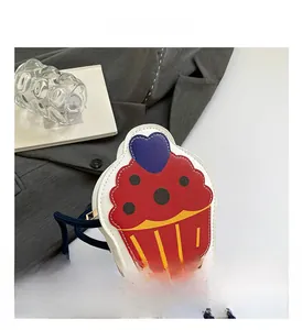 Detailed view of cupcake-shaped red crossbody bag with purple heart and blue rope strap