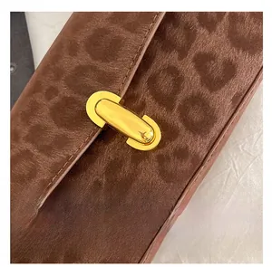 Detail of trendy gold oval buckle on leopard print suede texture shoulder bag
