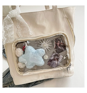Détail du sac cabas crème avec fenêtre PVC transparente et ruban en dentelle chic