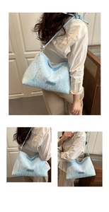 Close-up of light blue leather tote bag with colorful embroidery and fashion tag