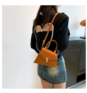 Détail d'un sac à main trapèze marron en cuir PU avec fermoir doré et bandoulière fine