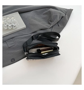Internal view of piano crossbody bag showing capacity for phone and cosmetics