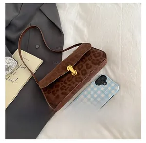 Detailed size comparison of leopard print baguette bag next to a smartphone