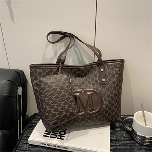 Retro coffee brown monogram tote bag set with embossed M logo on a white book