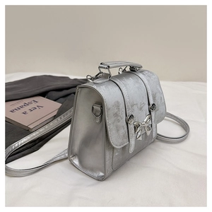 Detailed view of silver bow backpack with metallic finish and buckle closure