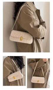 Detail of minimalist cream leather underarm bag with gold twist-lock and leopard print